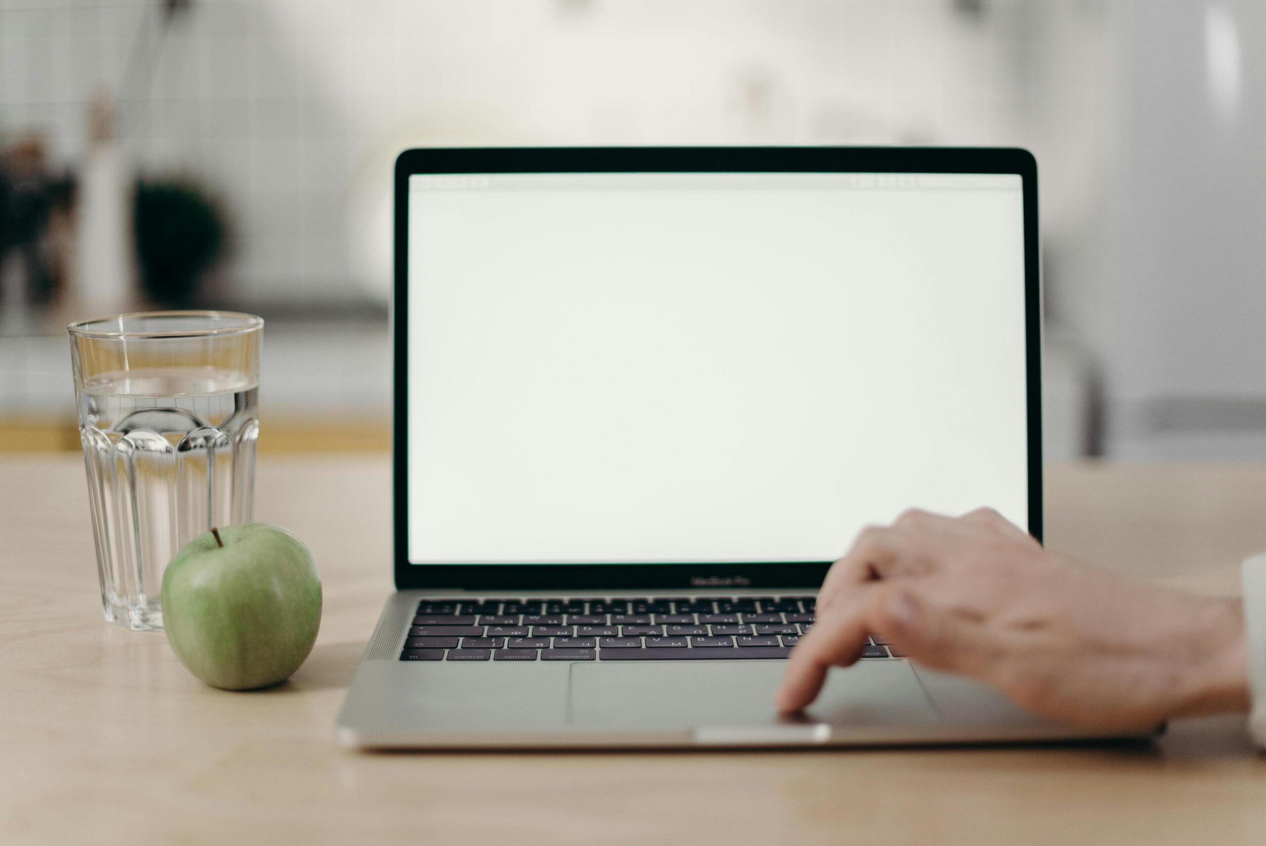 Typing on a blank Macbook screen on a table
